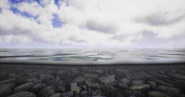 CGI Beneath surface, smooth pebbles rest on the ocean floor video