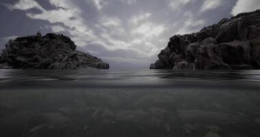 CGI Calm water surface reflects clouds between rocky cliffs at twilight video