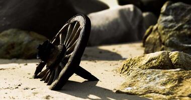 CGI Rusty metal object lying on the sandy beach among large stones at dawn video