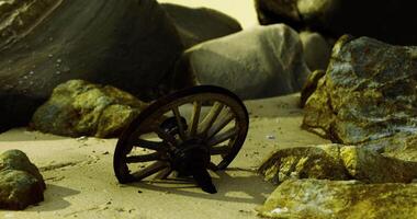 CGI Old wooden cartwheel rests on sandy beach surrounded by large rocks video