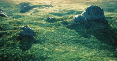 CGI Rolling hills with large rocks and glowing lights under soft sunlight video