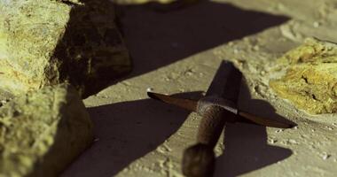 CGI Sword resting on sandy ground surrounded by rocks in natural light video
