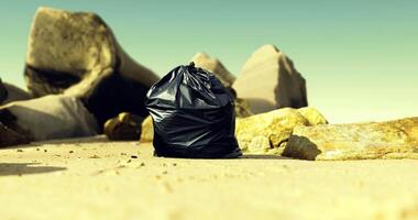 CGI Black trash bag on sandy beach near large rocks under clear sky video