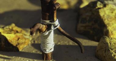 CGI Wooden stick secured with rope among rocks at a sandy location during daylight video