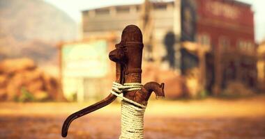 CGI Old water pump with rope surrounded by rustic buildings in desert sunlight video