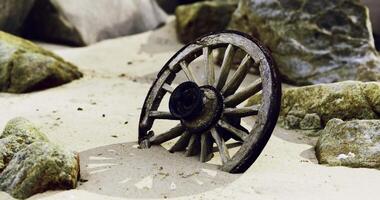 CGI Old wooden wheel partially buried in sandy terrain surrounded by rocks video