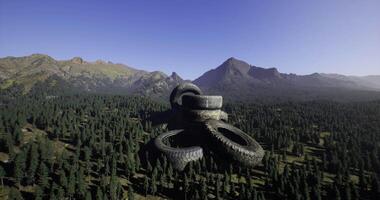 CGI Old tires stacked in a forest during bright afternoon sunlight video