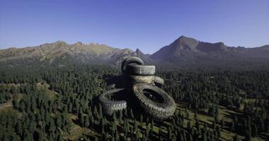 CGI Large stack of tires in mountainous forest landscape during clear day video