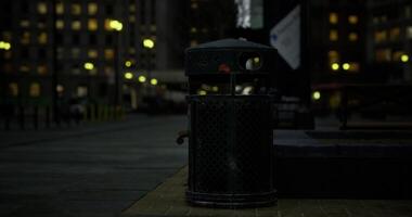 CGI Trash bin illuminated by street lights in urban city after dark video