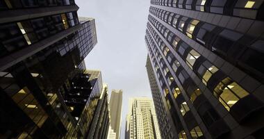 CGI High rise buildings reaching into the clouds in an urban setting at dusk video