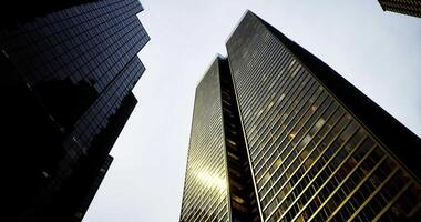 CGI Tall glass skyscrapers reflecting light in an urban skyline during twilight video