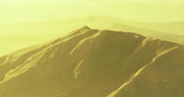 CGI Serene golden landscape with rolling hills under warm sunlight rays video