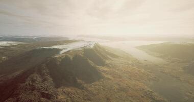 CGI Sky view over rugged mountains and winding river in early morning light video