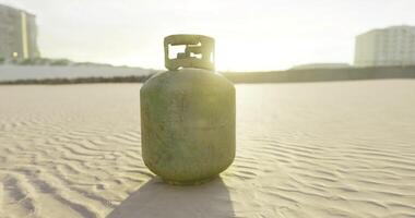 CGI Gas cylinder resting on sandy terrain during golden hour at the beach video