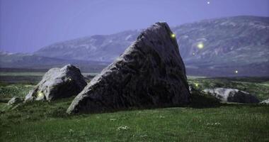 CGI Large rocky formation illuminated by fireflies at dusk in a serene landscape video
