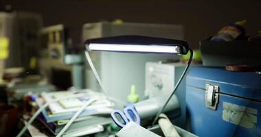 CGI Workspace cluttered with tools and a bright desk lamp illuminating the area video