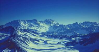 CGI Majestic snow covered mountain range under clear blue sky at twilight video