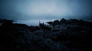 CGI Mysterious boat remains on a rocky shore under a foggy twilight sky video