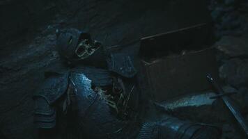 CGI Old knight remains found resting in a dark cave near a treasure chest video
