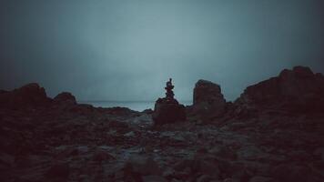 CGI Calm rock formation balanced on shore during twilight near ocean video