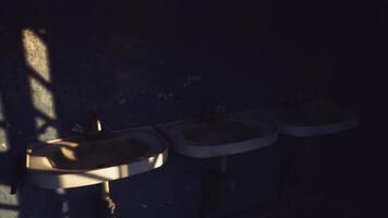 CGI Three old sinks in a dimly lit room highlighting neglect and decay video