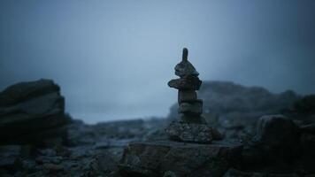 CGI Rock formation stands alone in misty coastal landscape at dusk video