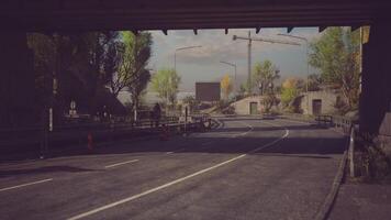 CGI Curved road beneath a bridge with trees and construction in the background video