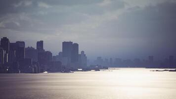 CGI Twilight city skyline reflects on calm coastal waters video