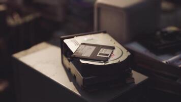 CGI Hard drive and floppy disk placed on a dusty table in a cluttered workspace video