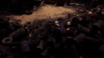 CGI Black and blue tires piled on a dim concrete floor in a cluttered shop video
