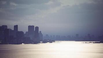 CGI Overcast skyline view of a bustling city by the tranquil water at dusk video