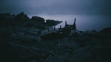CGI Abandoned wooden boat resting on a rocky shore at twilight video