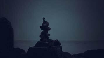 CGI Stacked stones create a serene monument at the water edge during twilight video