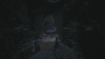 CGI Mysterious cave entrance illuminated by flickering light in ancient terrain video
