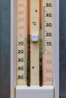 Temperature gauge provides a clear view of the outdoor conditions on a bright sunny day, reflecting varying degrees from freezing to hot photo
