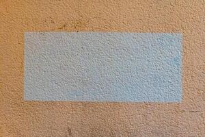 Unsung textures reveal hidden stories on a weathered wall in a quiet urban setting, offering a glimpse into the passage of time and change photo