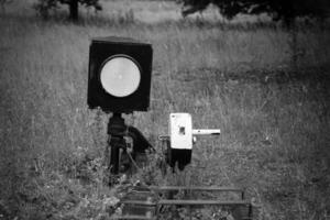 Rail signal and control lever standing alone in the overgrown grass, hinting at stories from a forgotten rail line photo