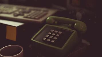 CGI Vintage green telephone on a desk with a keyboard and coffee cup at night video