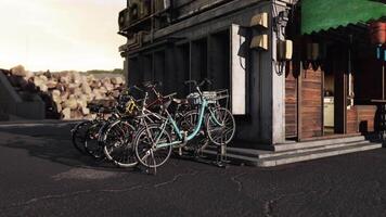 CGI Bicycles parked near a rustic building with a green awning in a coastal area video