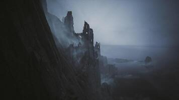 CGI Dark and misty coastal ruins rise above the ocean waves at dusk video