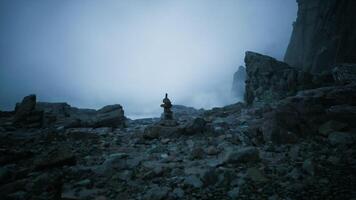 CGI Misty coastal rocks with stacked stones at dawn on a quiet beach video