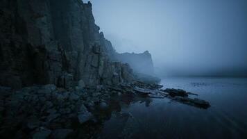 CGI Misty coastal landscape with rocky cliffs and calm waters at twilight video