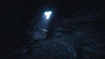 CGI Light filters through a dark cave revealing rocky terrain and shadows video