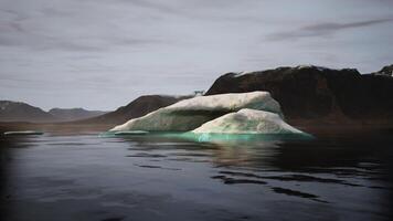 CGI A solitary iceberg floats in tranquil waters surrounded by rugged mountains video