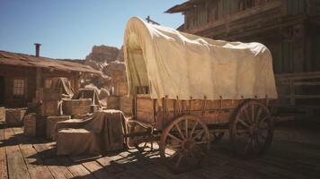 CGI Old wooden wagon with a covered top sits in a western town at midday video