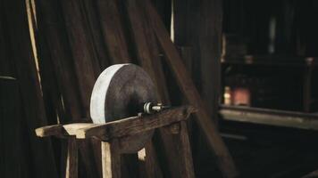 CGI A rustic stone grinding wheel on a wooden stand in a cozy workshop setting video