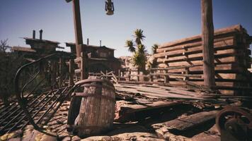 CGI Abandoned wooden structures and barrel in a deserted mountain town at sunset video