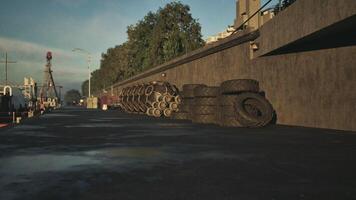 CGI Sunset at riverside dock with stacked tires and machinery nearby video