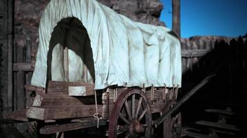 CGI Old wooden wagon with a canvas cover resting in a rustic settlement video