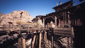 CGI Rustic wooden bridge leading to an old mining structure in a desert landscape video